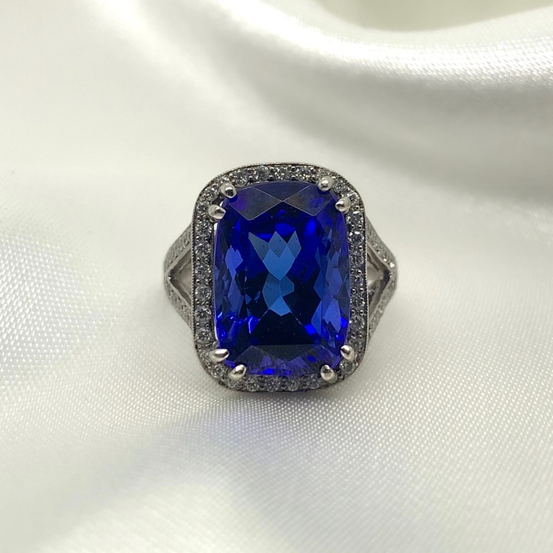 Clara Statement Ring, cushion-cut tanzanite with pave diamond halo and split shoulders, platinum, from Ebony Jewellers Chichester