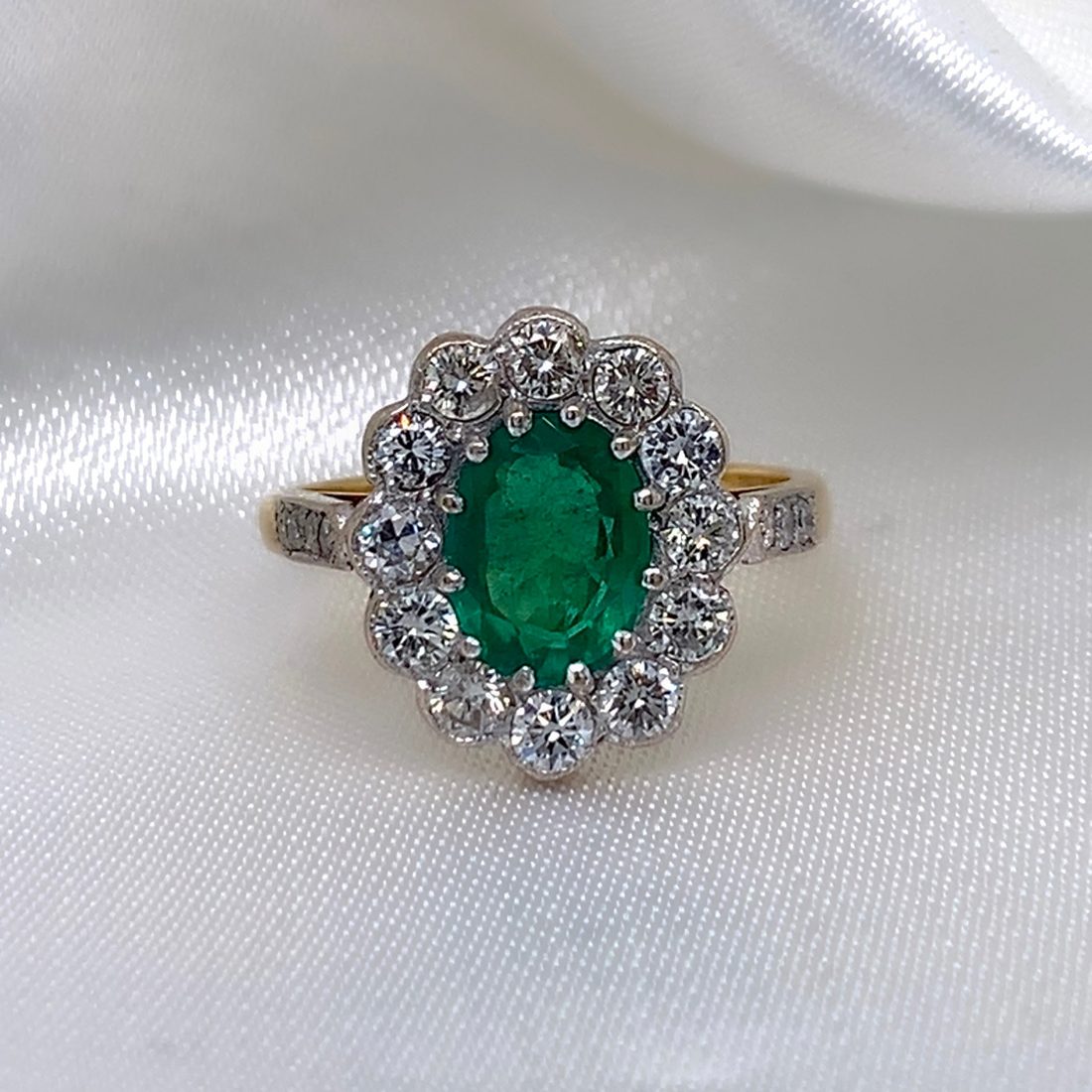 Josephine Cluster Ring, oval emerald surrounded by diamond cluster, 18ct yellow gold, from Ebony Jewellers Chichester