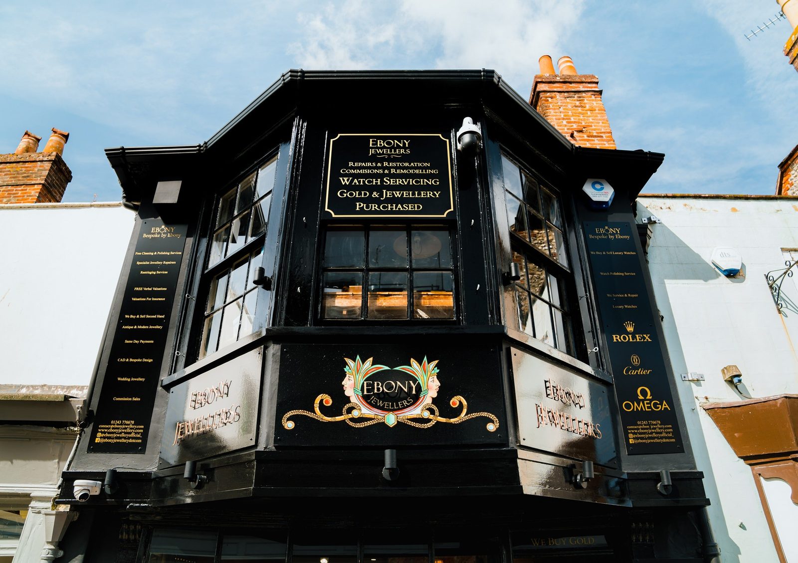 The black-and-gilt corner shopfront of Ebony Jewellers at 20 South Street, Chichester, with the gilt-scroll wordmark crest